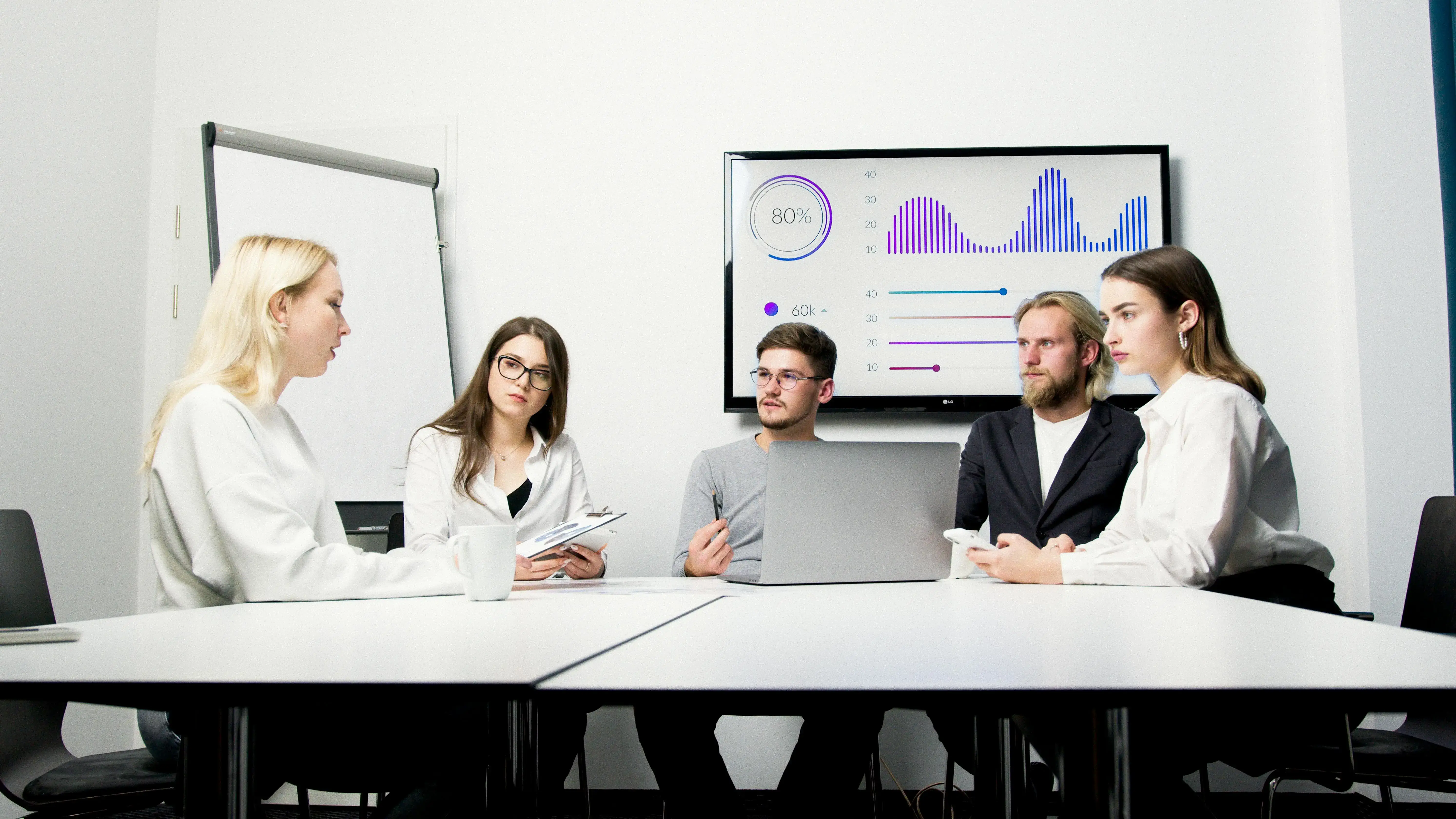 Colleagues collaborating in a modern meeting room, symbolizing effective teamwork and innovative tech solutions.