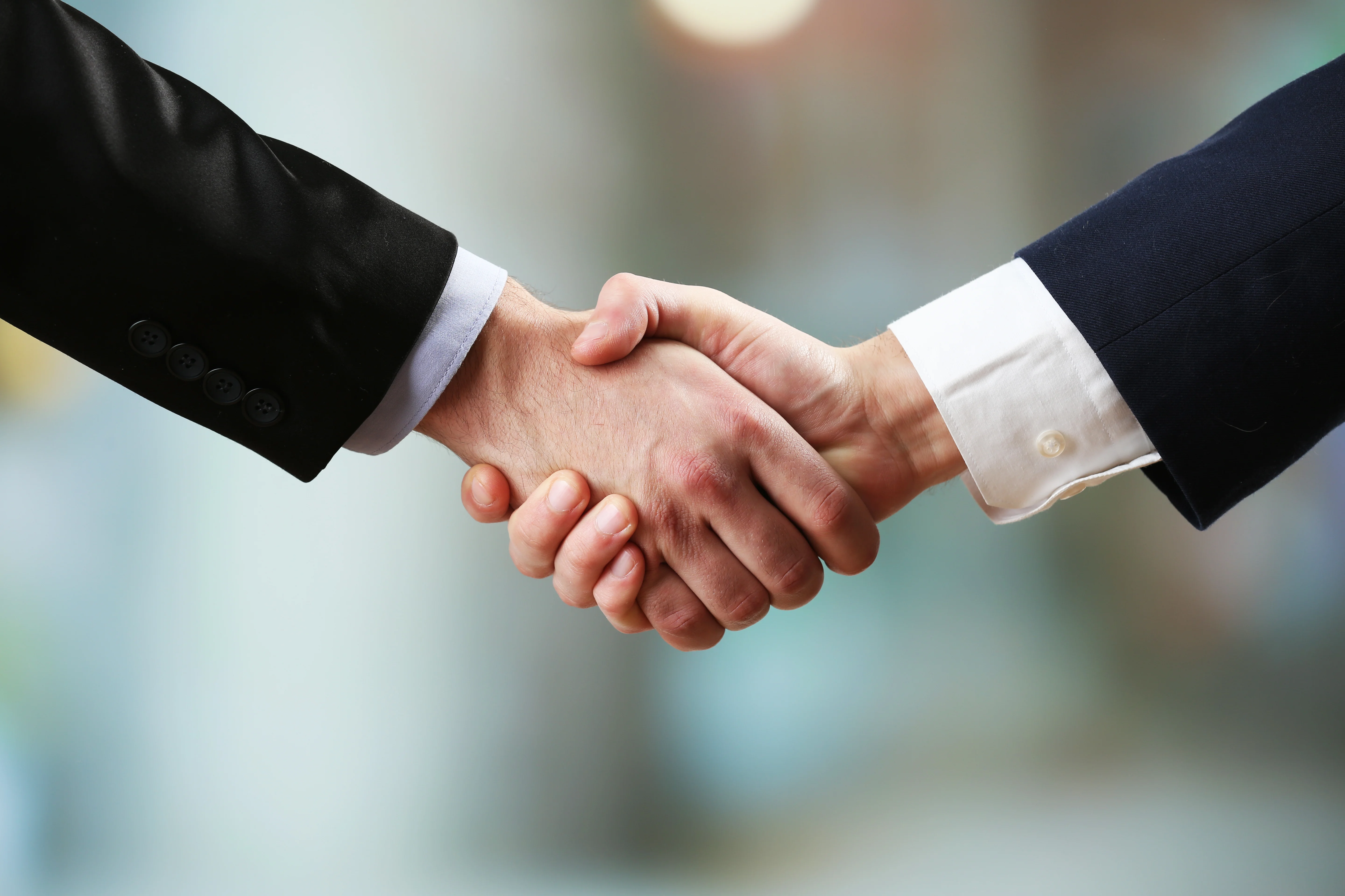 Business professionals shaking hands, symbolizing a successful partnership and trusted collaboration.